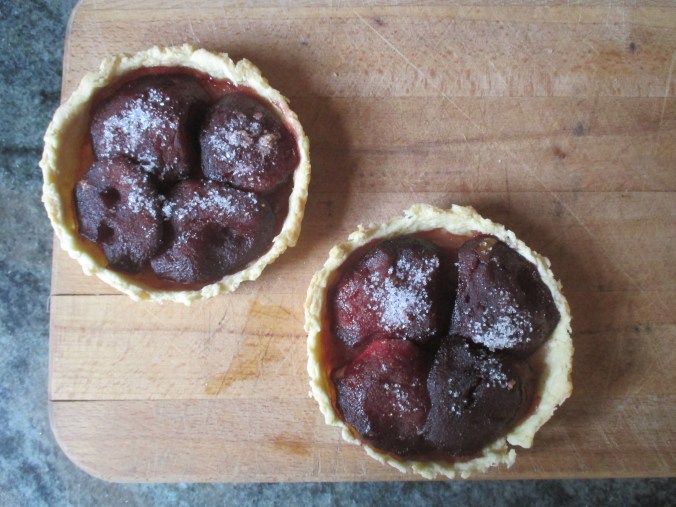 two cooked apple tarts on cutting board