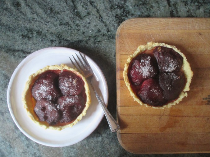 two cooked apple tarts, one on plate and one on cutting board