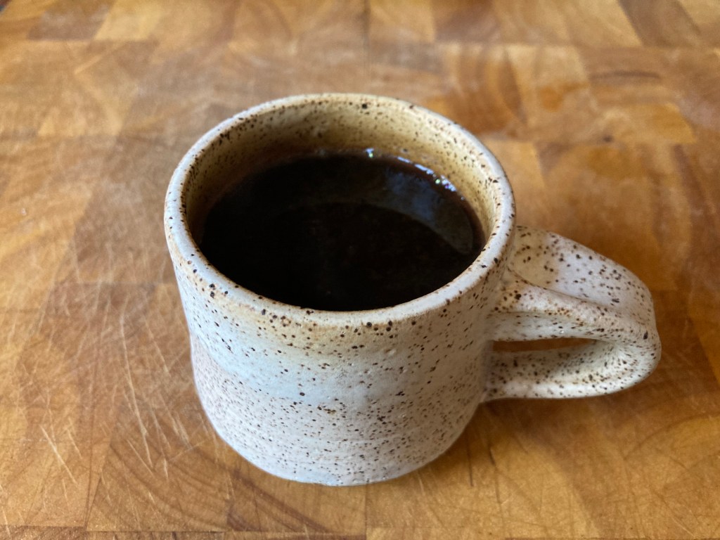 brewed coffee in white mug on cutting board