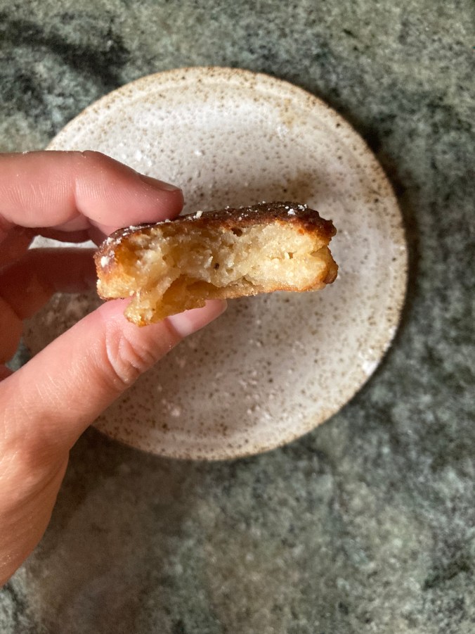 donut held in hand over plate