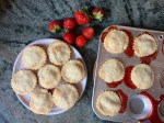 baked strawberry tarts on plate and in pan, strawberries on counter