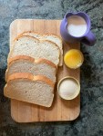 ingredients: bread on cutting board, sugar, orange juice, and cream in containers