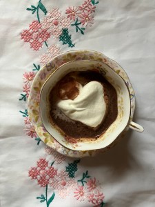 cloth background with hot chocolate in cup and whipped cream
