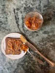 toast with peach preserves on plate with spoon and knife, jar of jam