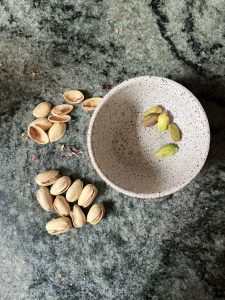 pistachios on countertop, shelled pistachios in bowl