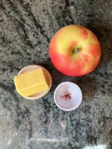 apple, butter, saffron strands in bowl on counter