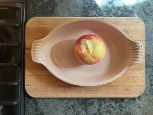 apple stuffed with butter and saffron in baking dish on cutting board on counter